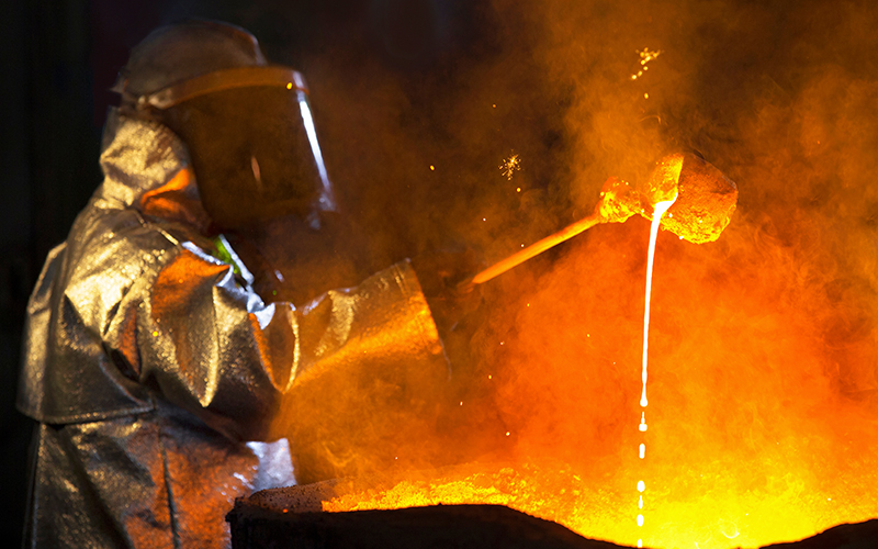 Steel worker monitoring molten steel temperature